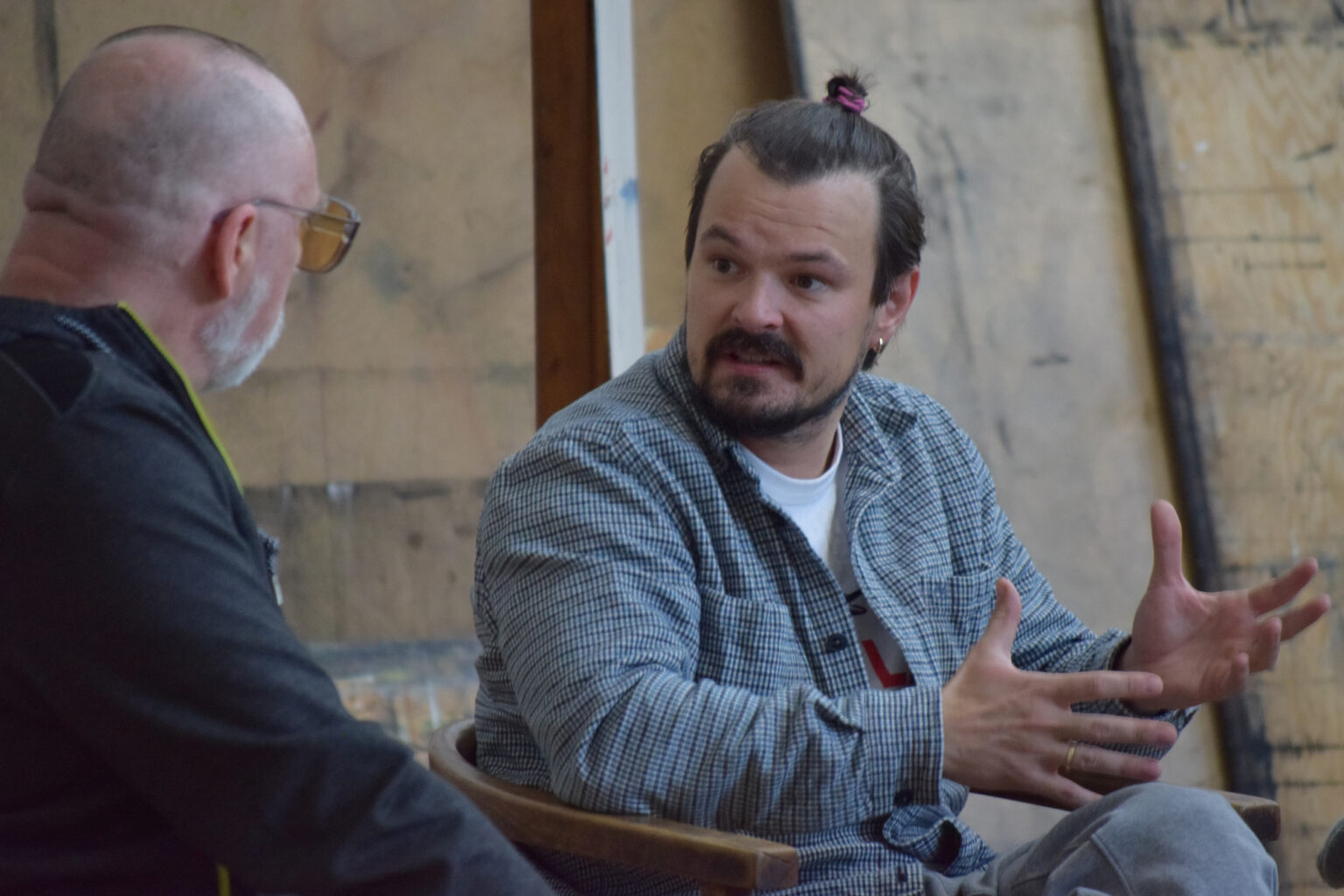 Dwóch mężczyzn. Jeden z nich opowiada coś drugiemu gestykulując