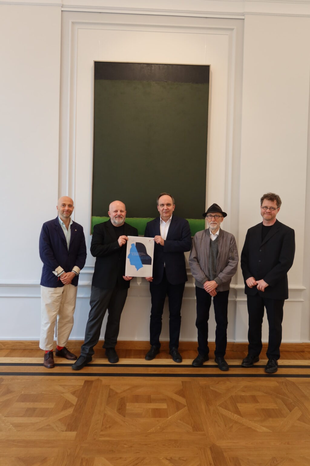 Zdjęcie pięciu mężczyzn stojących przy ścianie.