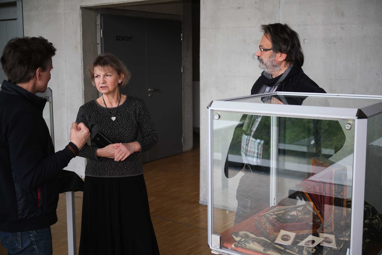 dwie osoby przy gablocie wystawienniczej
