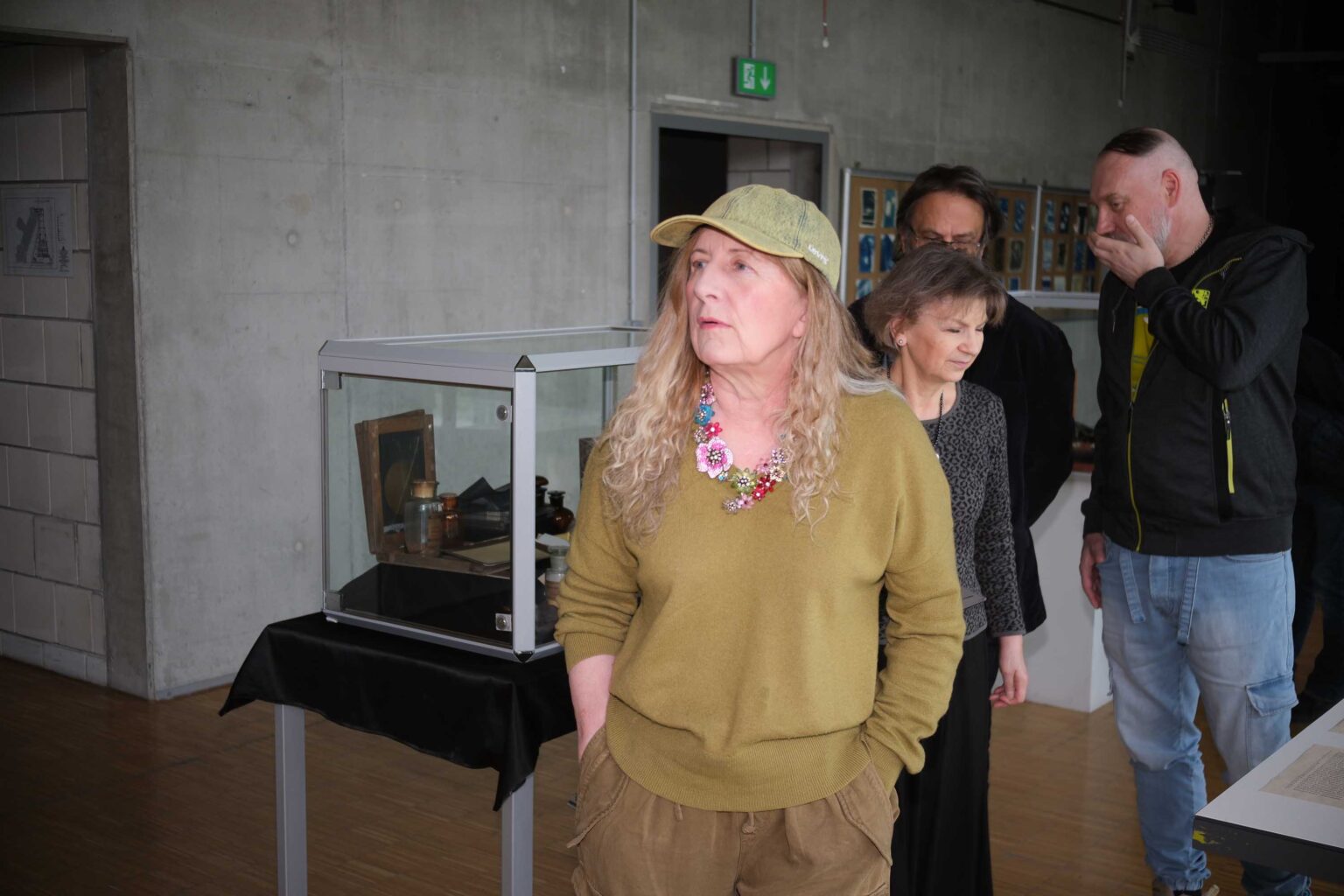 kobieta w czapeczce z daszkiem, wystaw w tle