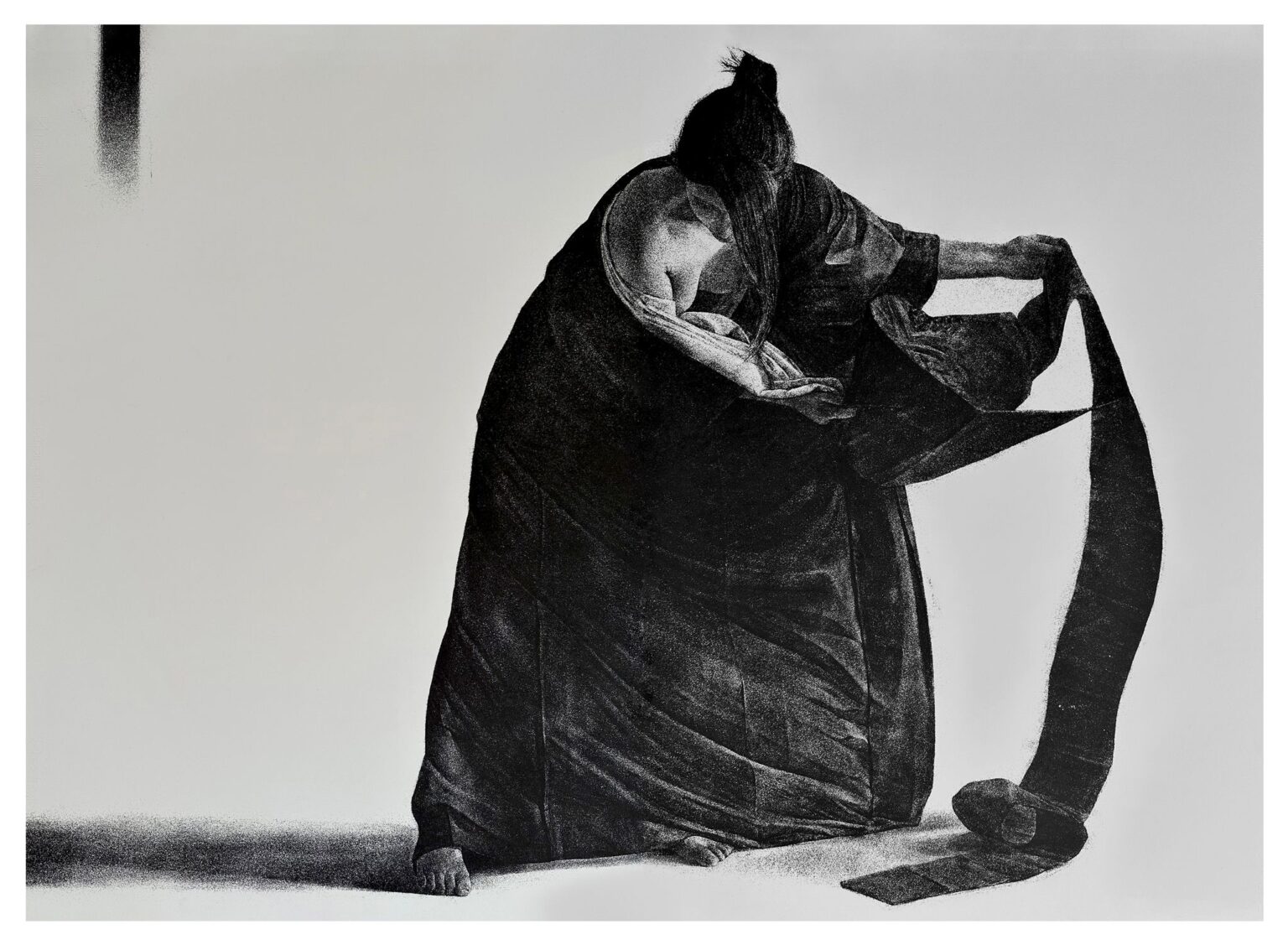 Grafika przedstawia kobietę w rozwianych szatach, trzymającą jej powiewający fragment w dłoniach. Grafika wykonana w technice odprysku korundowego.