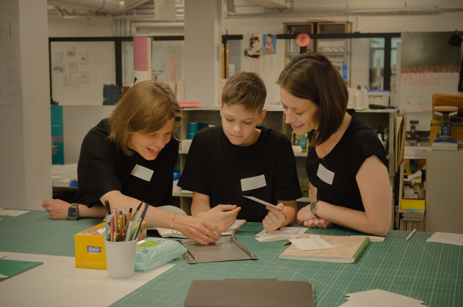 Trzy osoby przy biurku w pracowni