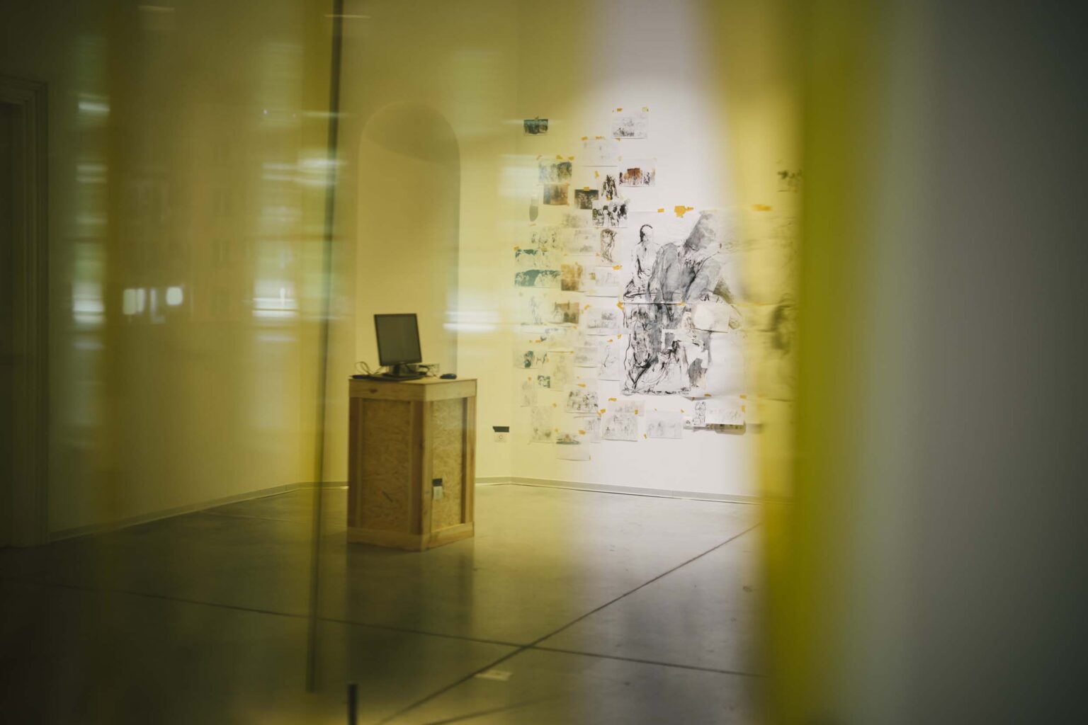 rysunki widziane z odległości przez żółta przesłonę w wejściu