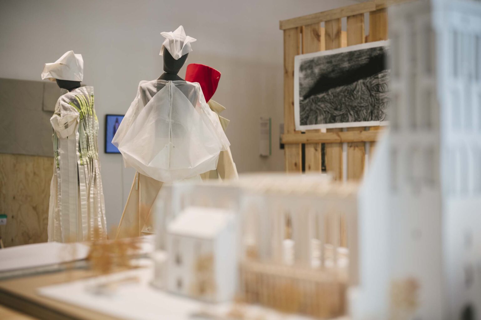 Sylwetki na manekinach, sitodruk czarno-biały w tle