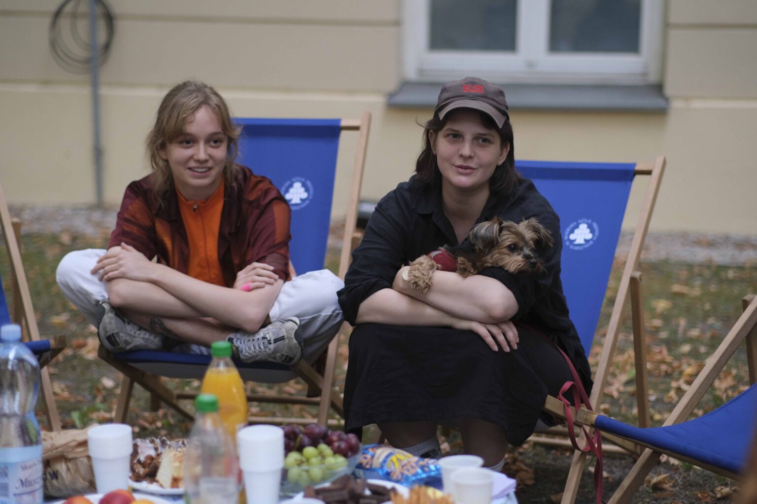 na zewnątrz: kilka osób na leżakach wokół stołu