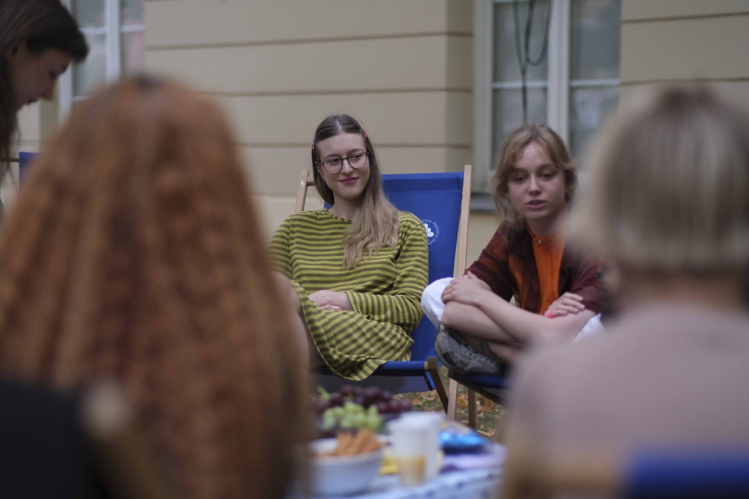 na zewnątrz: kilka osób na leżakach wokół stołu