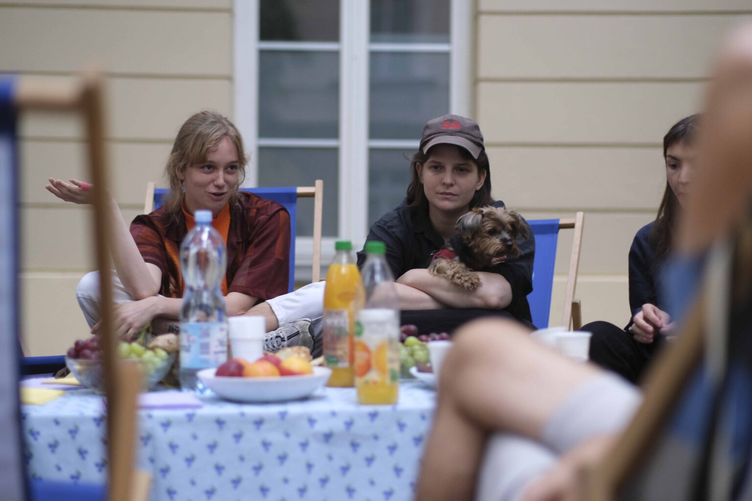 na zewnątrz: kilka osób na leżakach wokół stołu