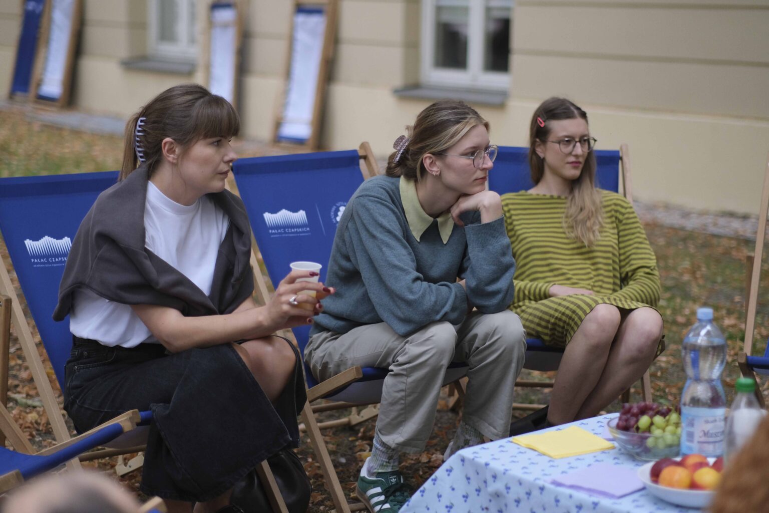 na zewnątrz: kilka osób na leżakach wokół stołu