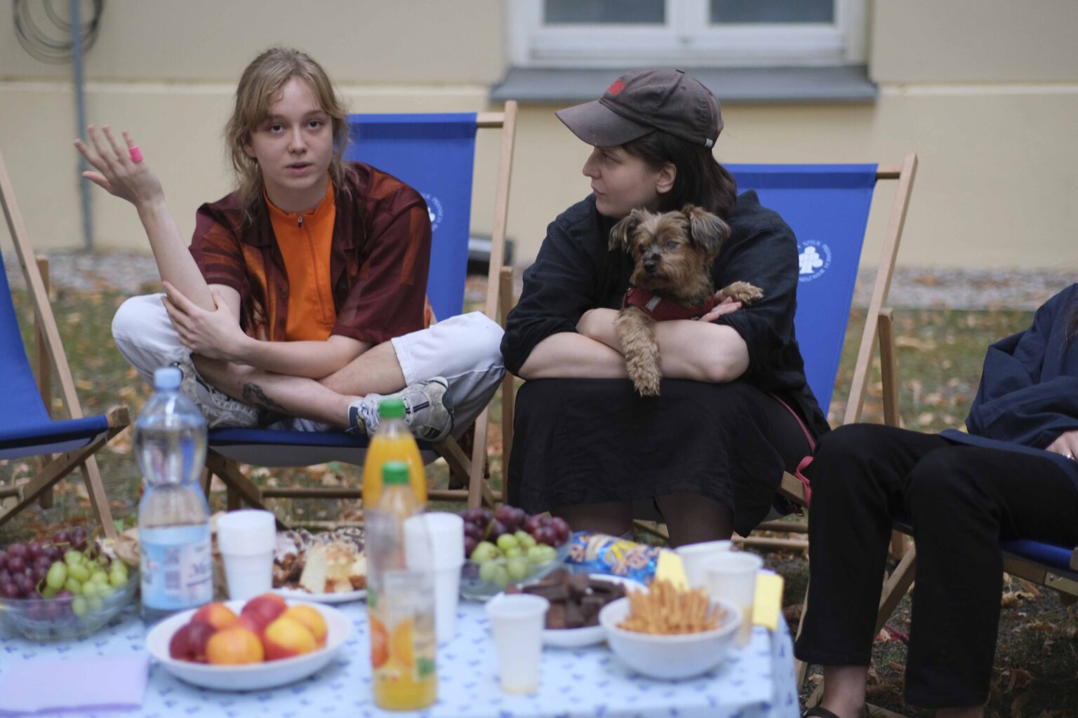 na zewnątrz: kilka osób na leżakach wokół stołu