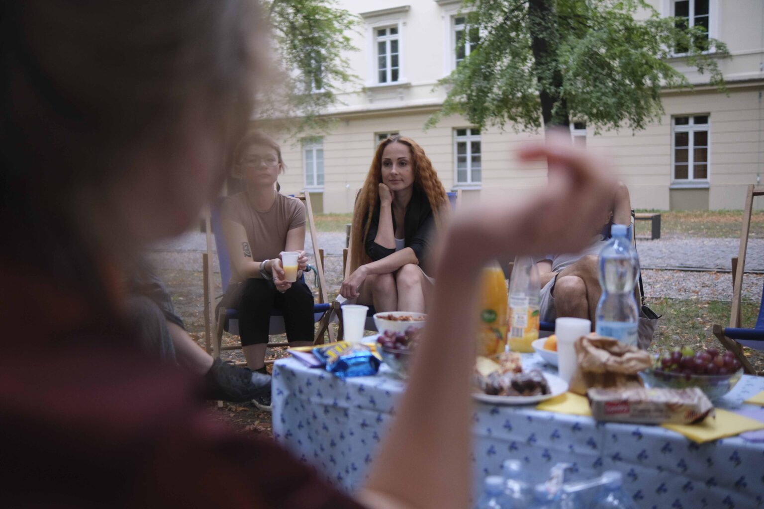 na zewnątrz: kilka osób na leżakach wokół stołu