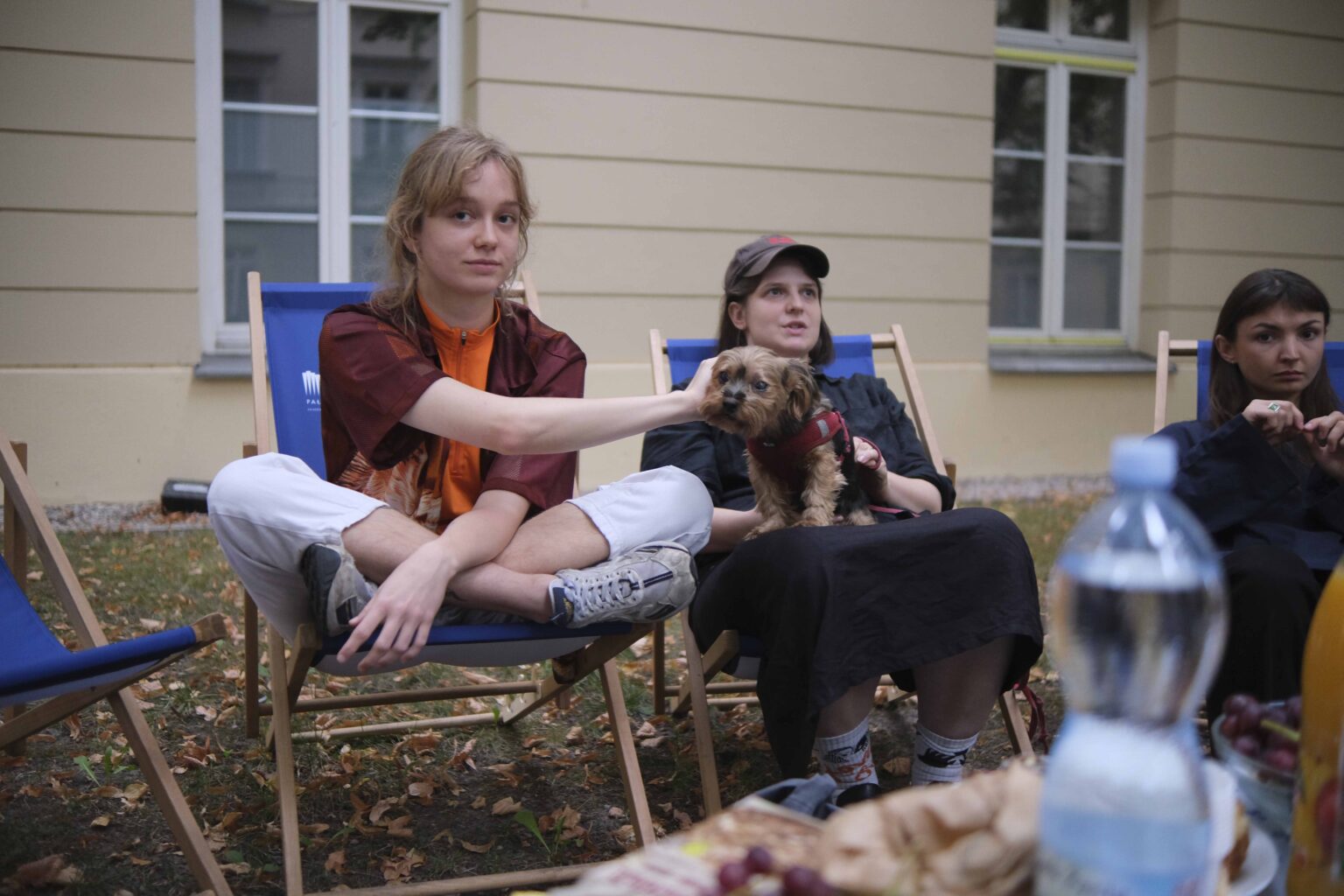 na zewnątrz: kilka osób na leżakach wokół stołu