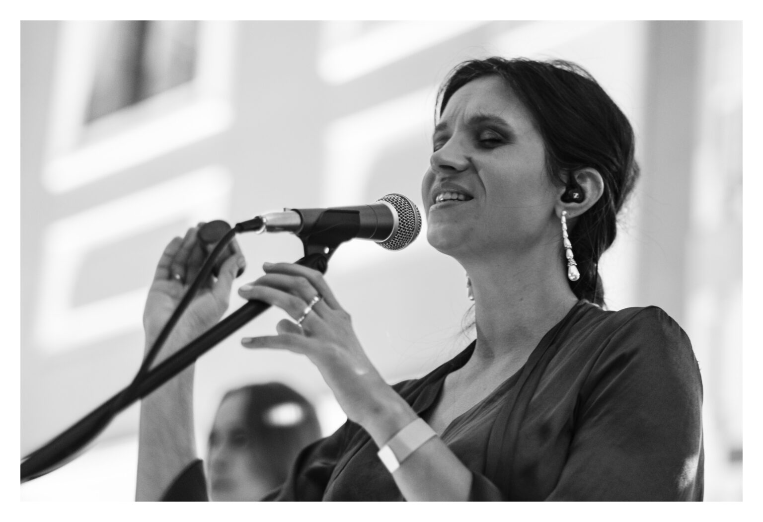 Kobieta śpiewająca do mikrofonu.