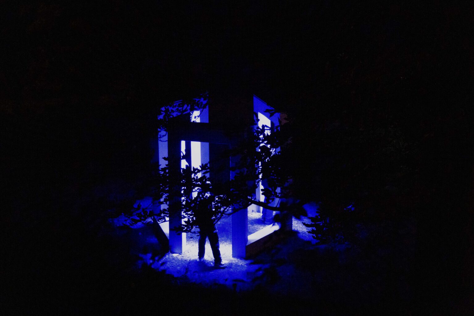 noc. osoby wewnątrz geometrycznej instalacji podświetlonej na niebiesko