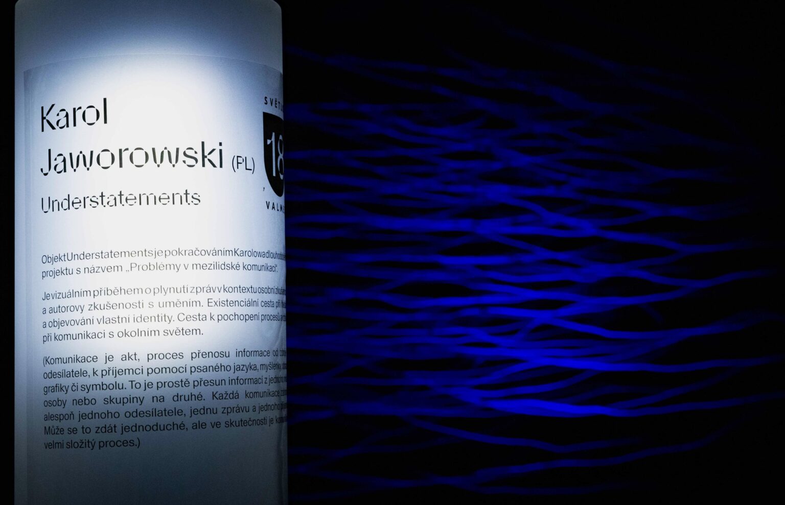 pozioma, niebieska instalacja świetlna nocą; fragment słupa ogłoszeniowego