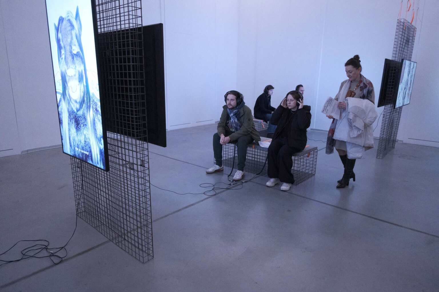 zwiedzający oglądają video na wystawie