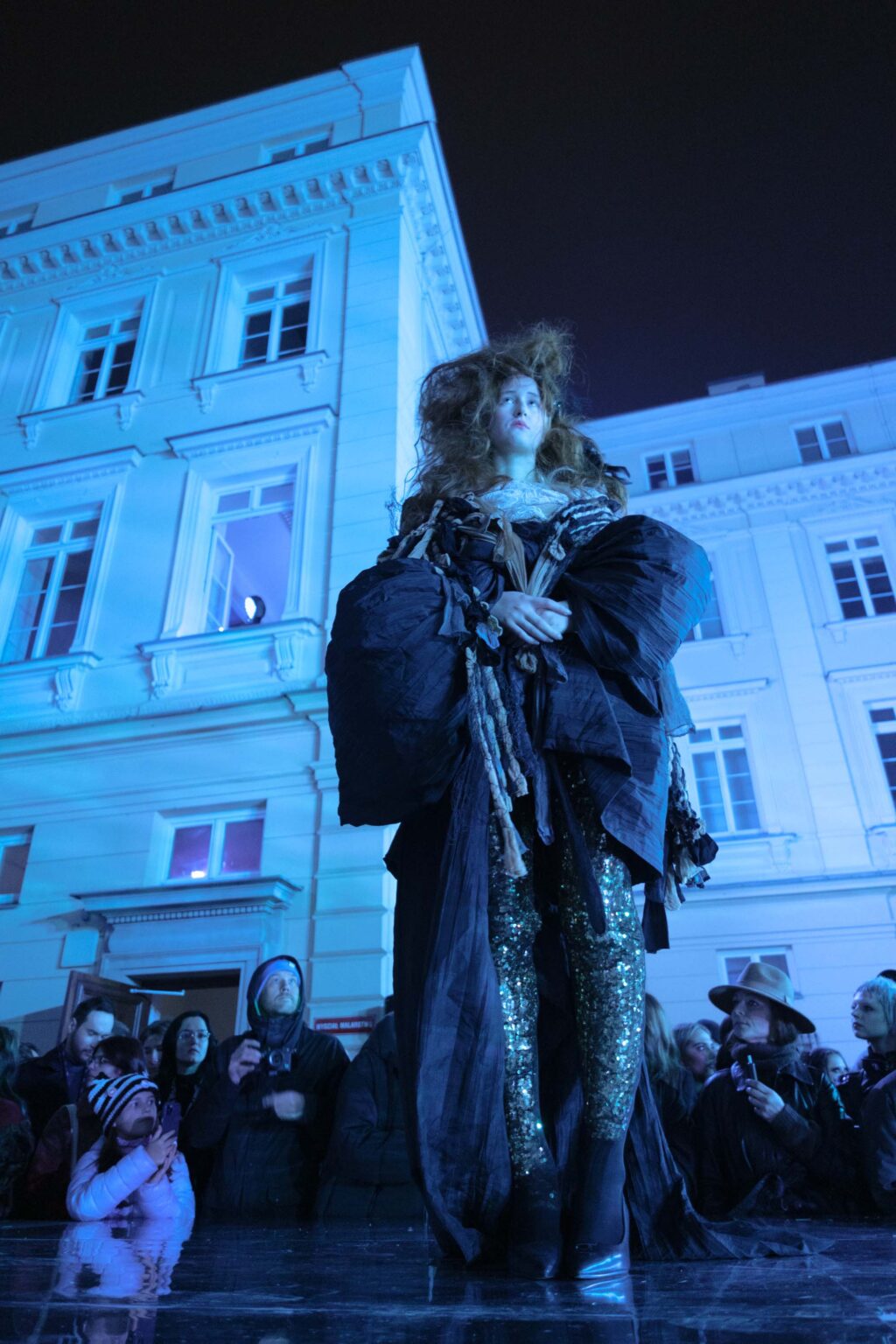 modelka na wybiegu, niebieskie światło, budynek w tle