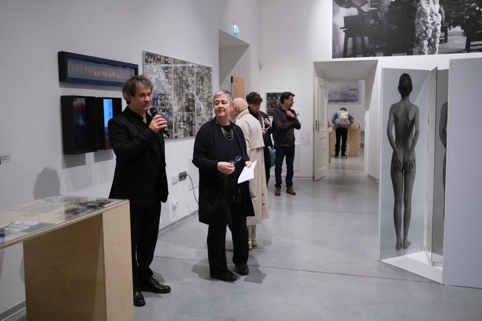 mężczyzna mówi do mikrofonu. Widok wystawy