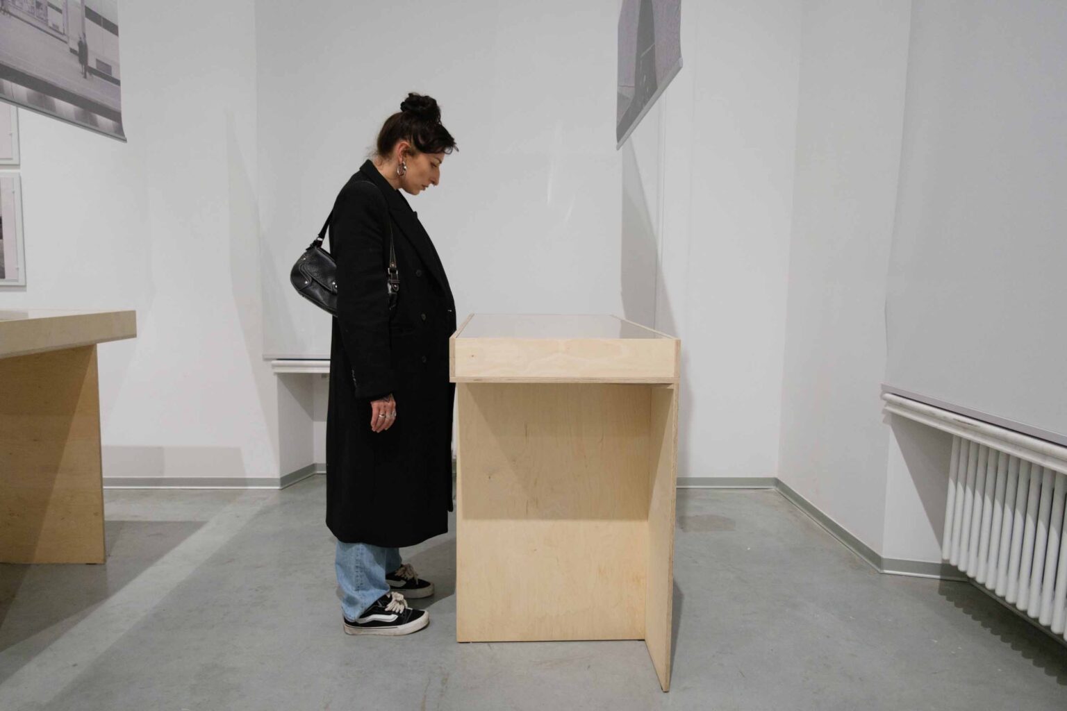 kobieta w płaszczu przy gablocie