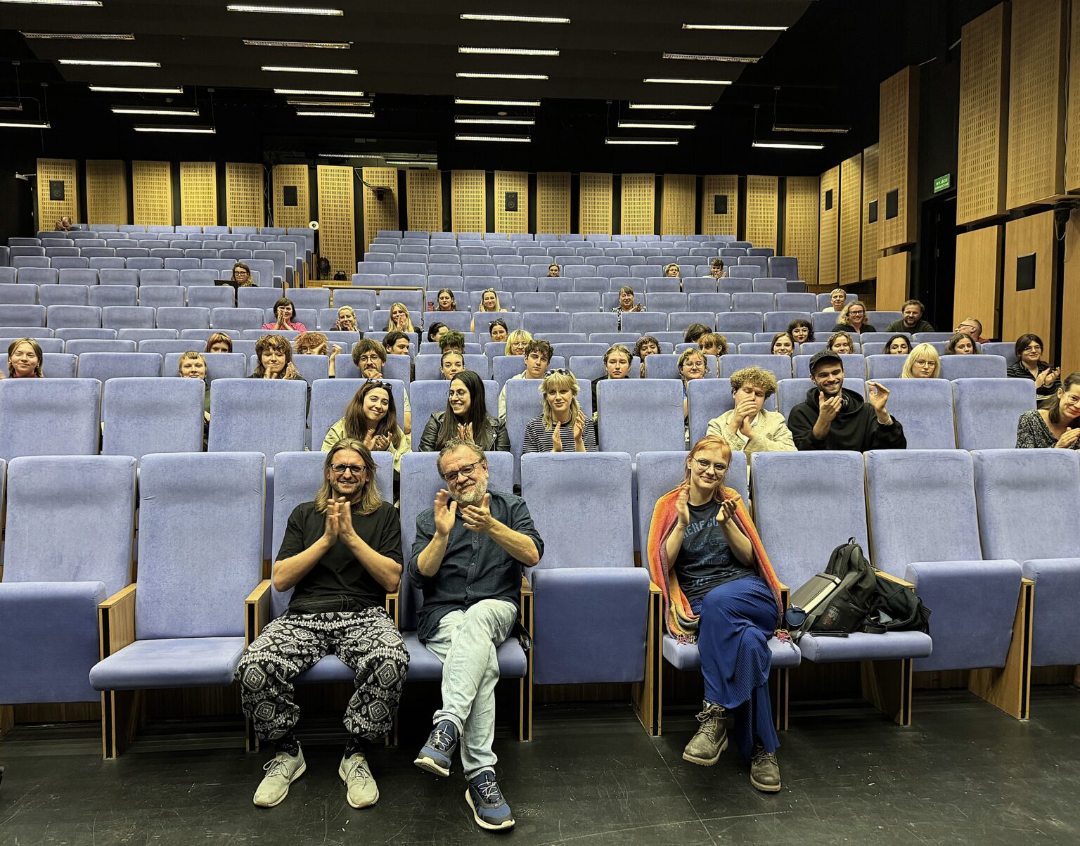 kilka osób siedzi w auli wykłądowej