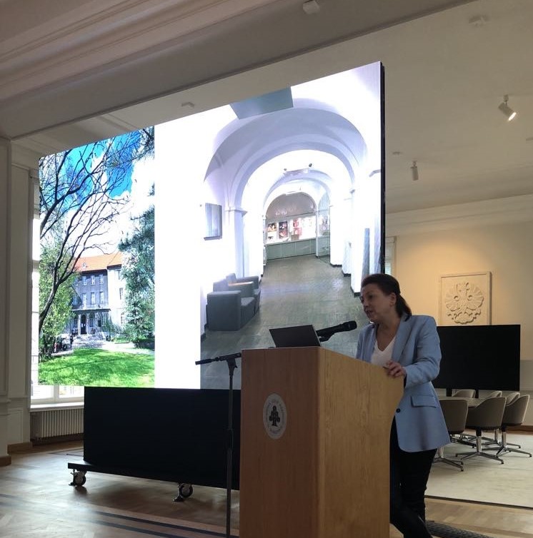 Kobieta przy mównicy. Prezentacja w tle