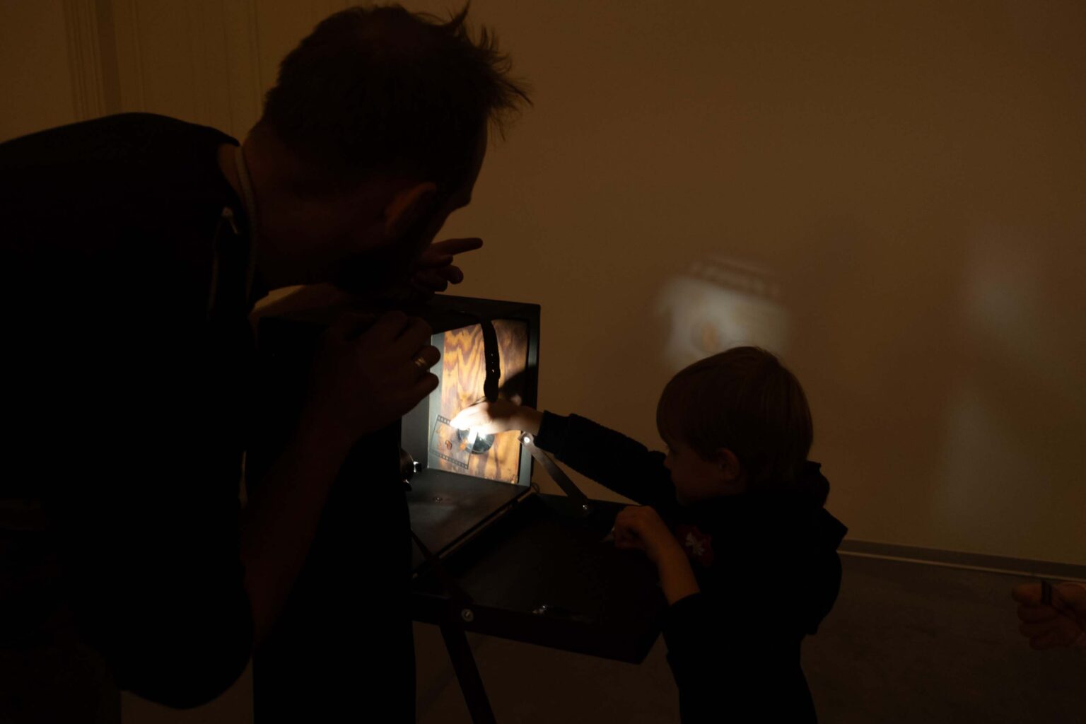 Chłopiec przygląda się kolorowym obrazkom wyświetlanym na ścianie