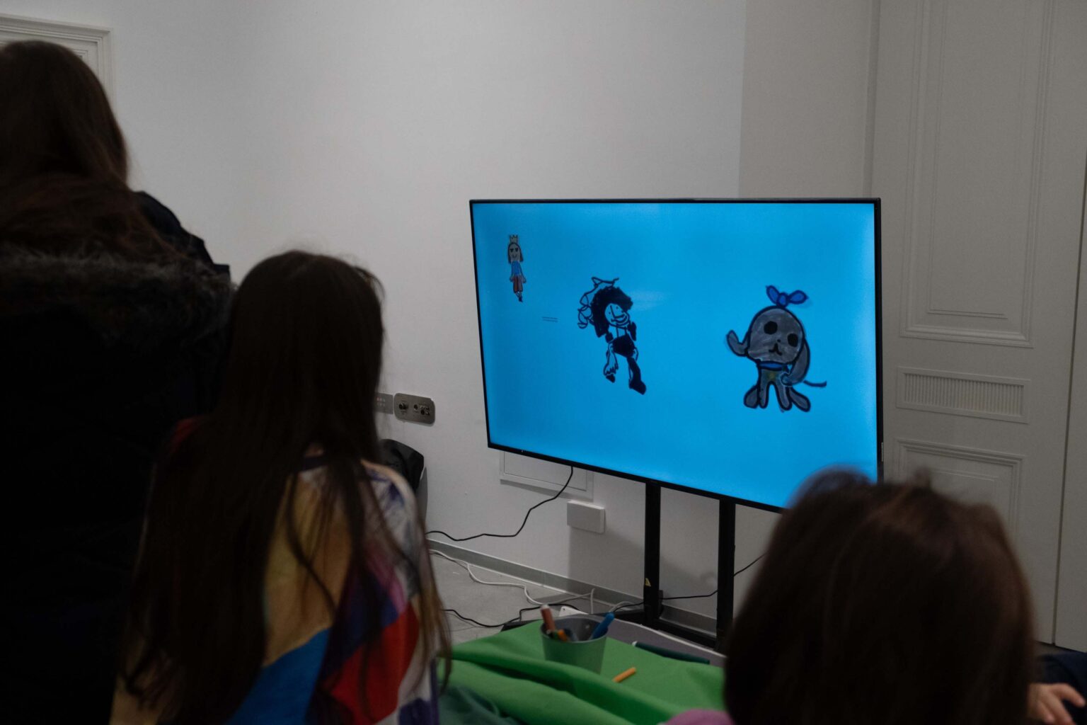 dzieci przed ekranem z rysunkami