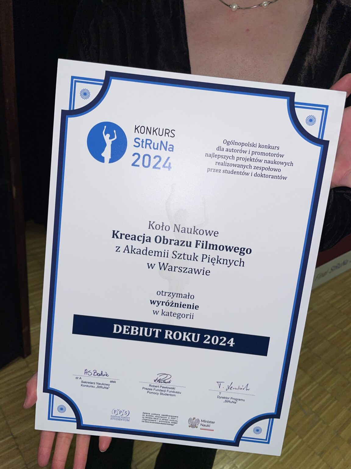 Zbliżenie na dyplom trzymany przez osobę