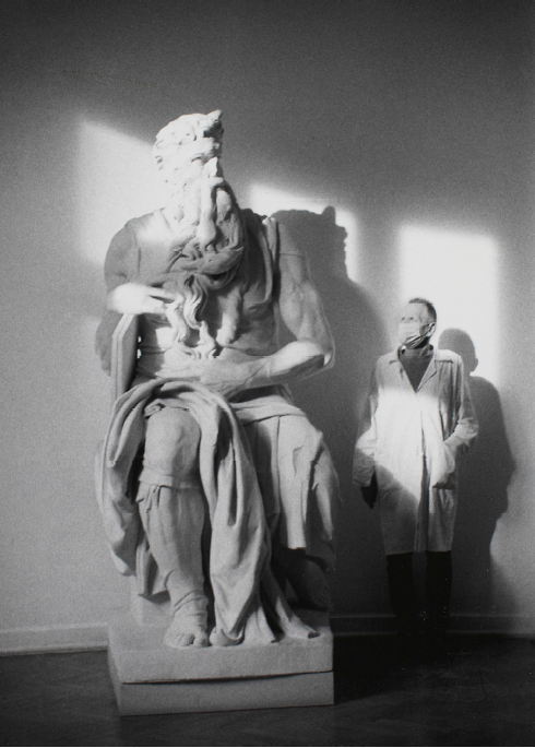 czarno-biały portret mężczyzny stojącego obok dużej rzeźby