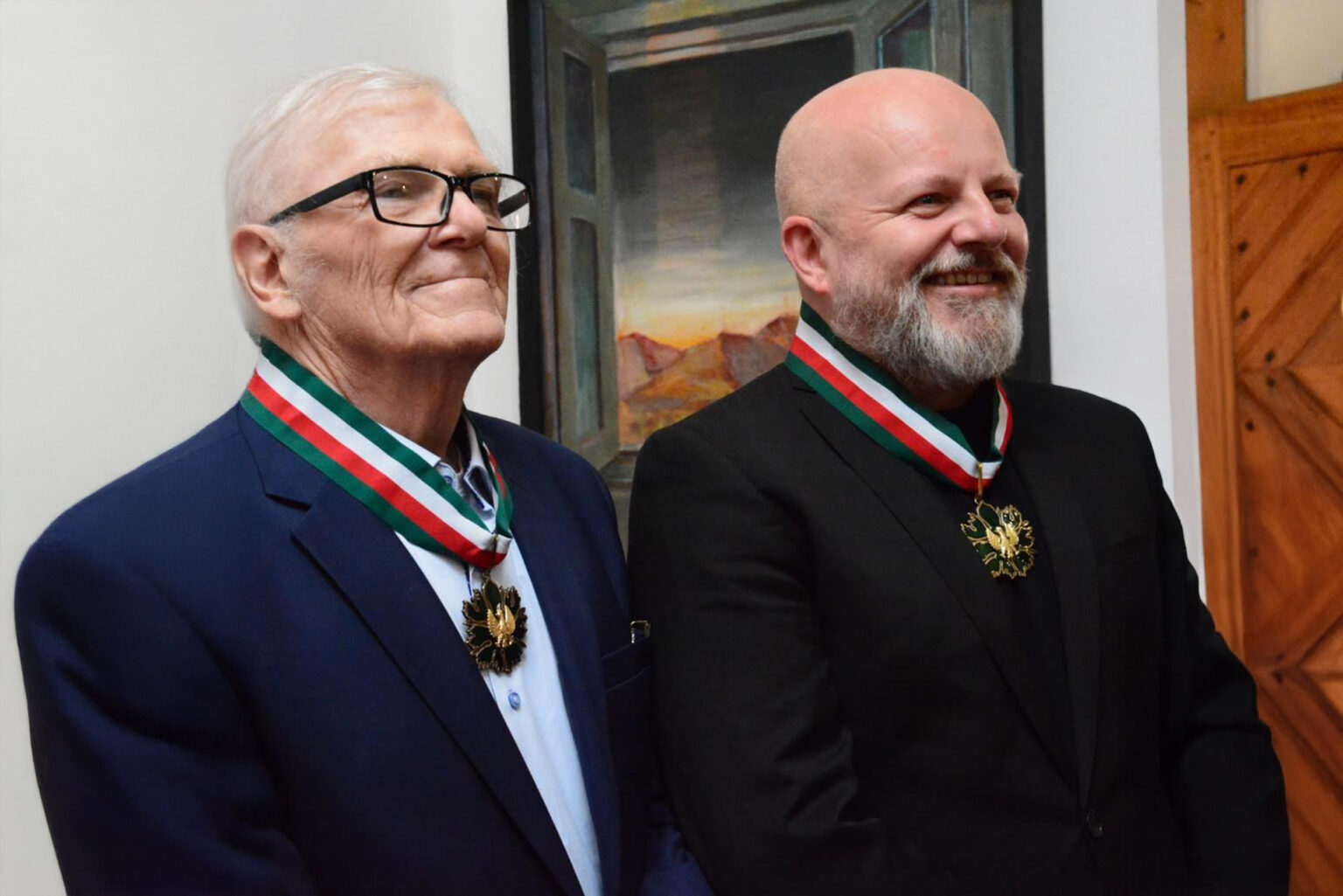portret dwóch uśmiechniętych mężczyzna z medalami na szyjach