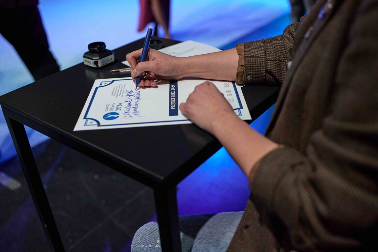 fragment postaci z dyplomem