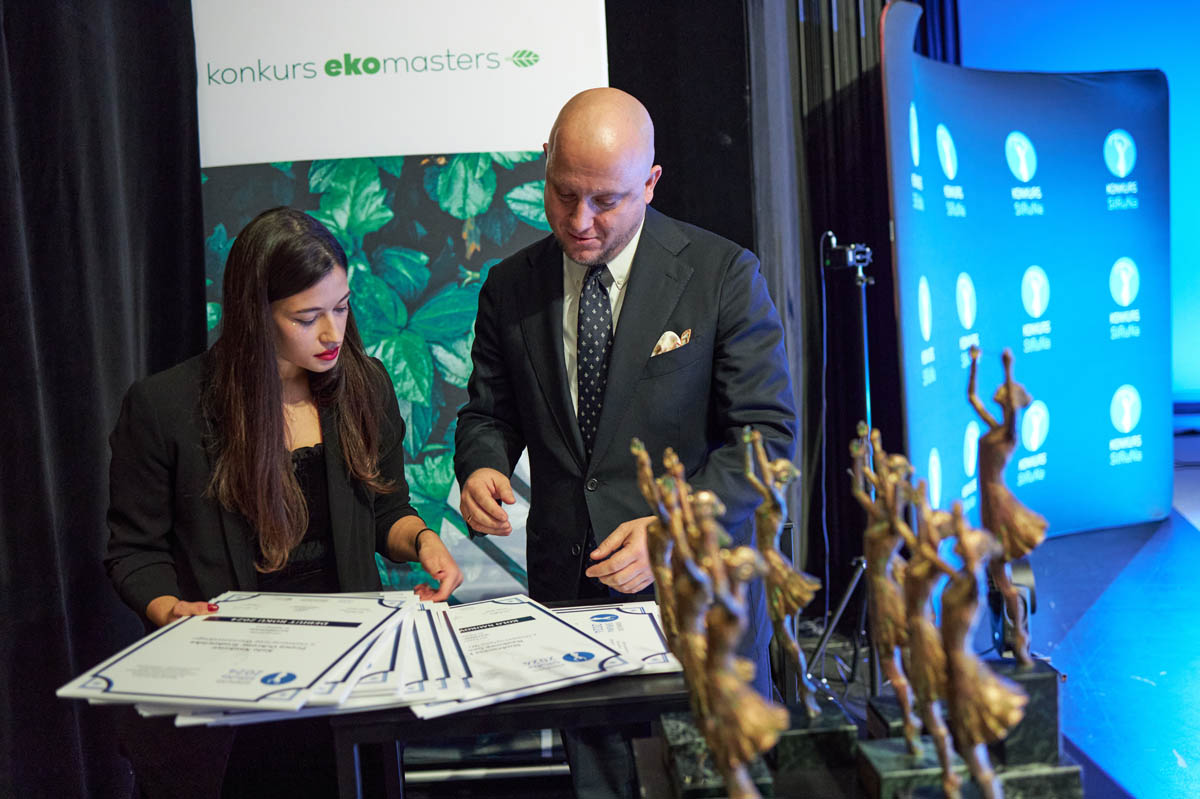 kobieta i mężczyzna przy stole z dyplonami