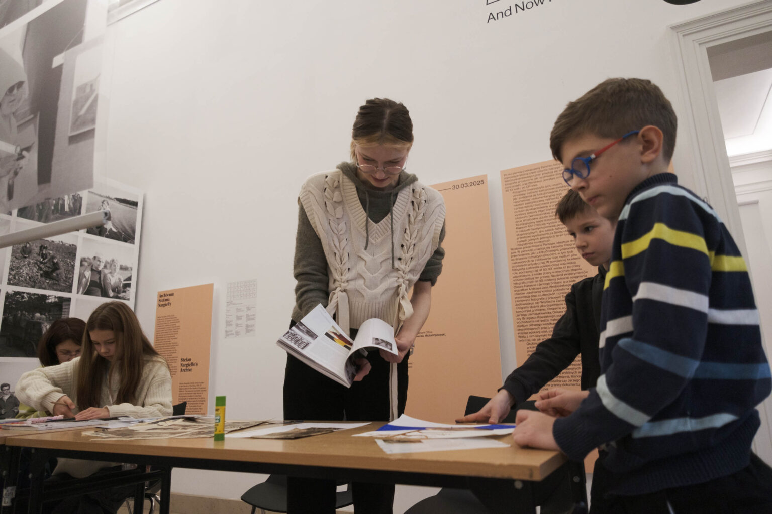 młoda kobieta i dzieci przy stole z materiałami plastycznymi