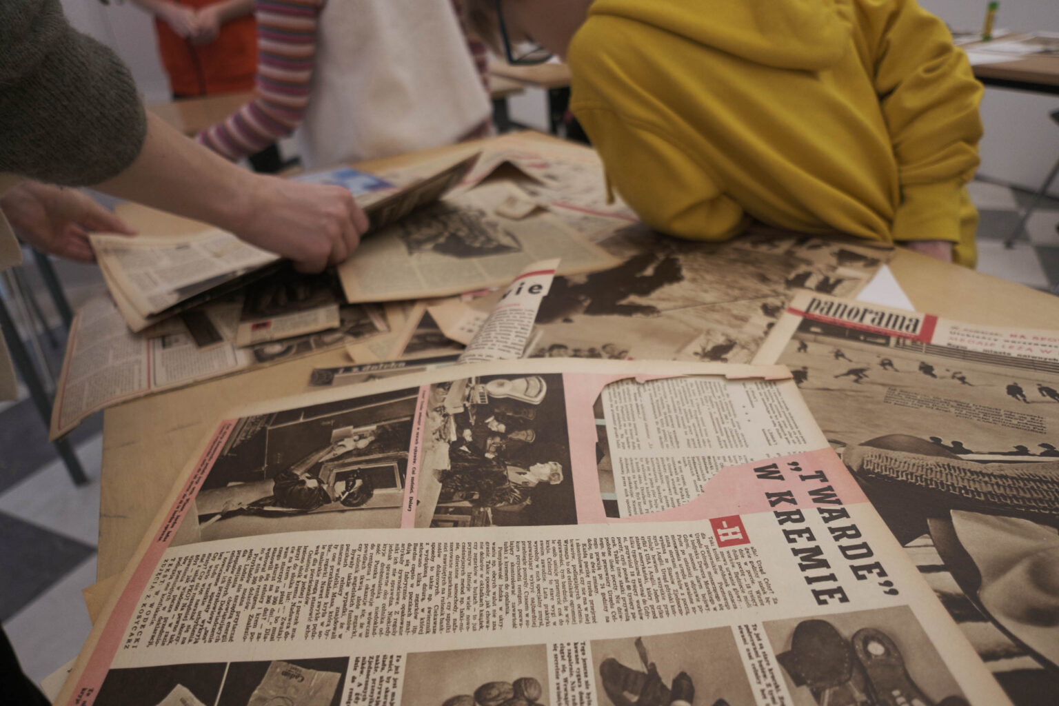 dzieci przy stole ze starymi gazetami