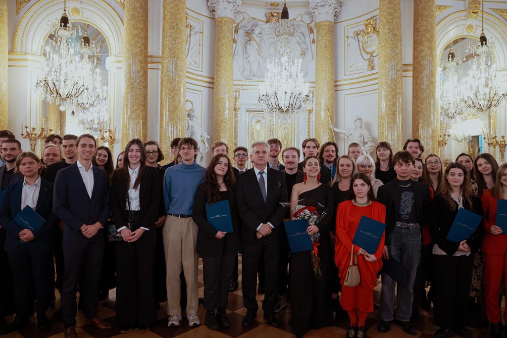 duża grupa osób w bogato zdobionym wnętrzu