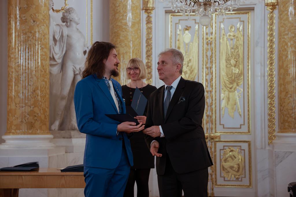 dwaj mężczyźni w bogato zdobionym wnętrzu