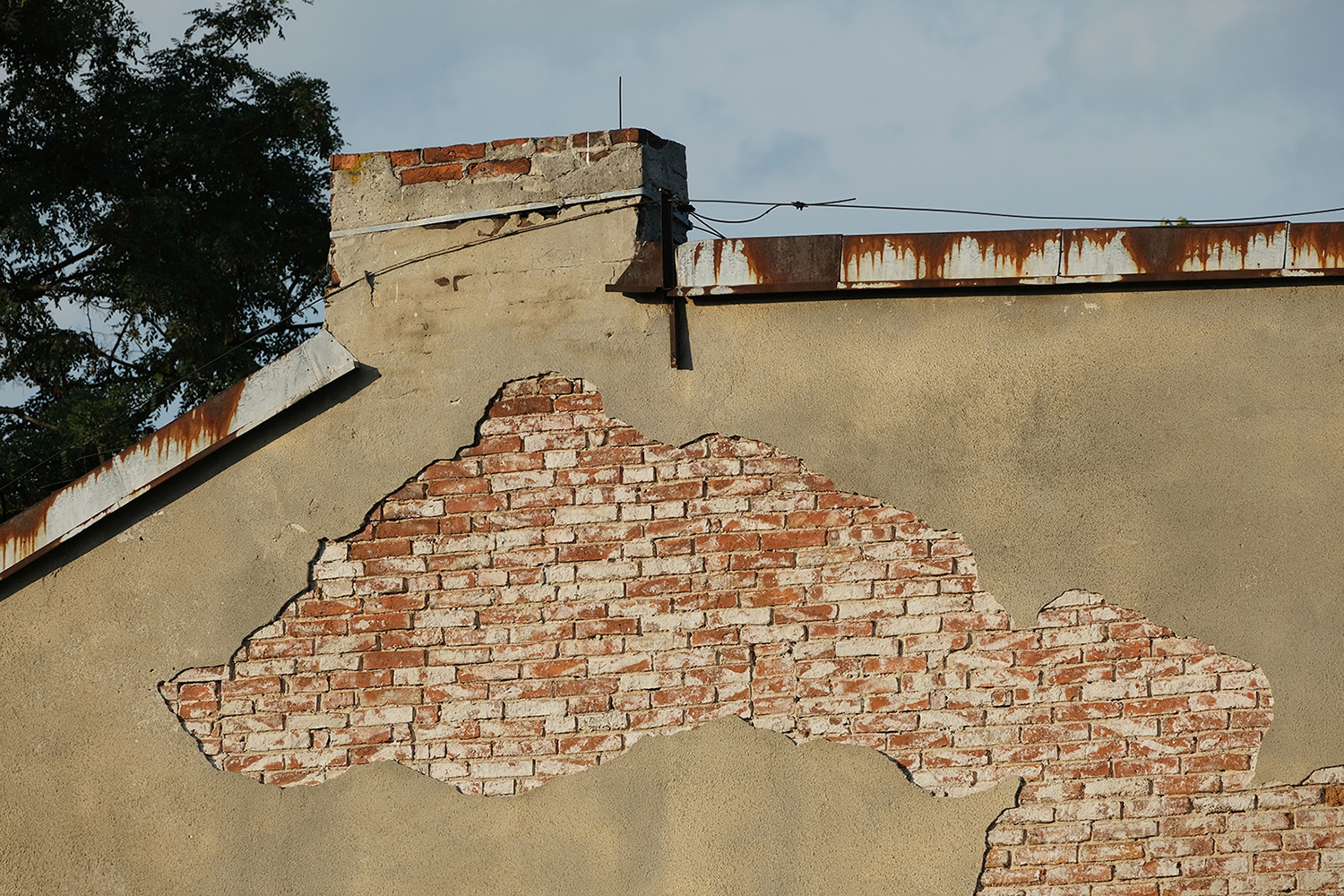 kolorowa fotografia muru budynku z fragmentem wystających cegieł