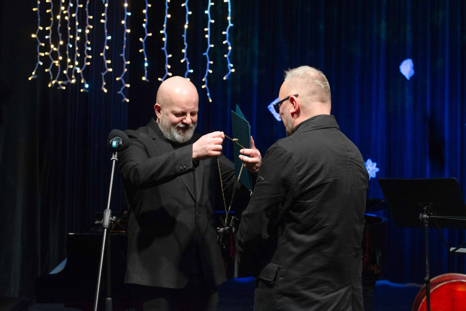 mężczyzna wręcza drugiemu odznaczenie