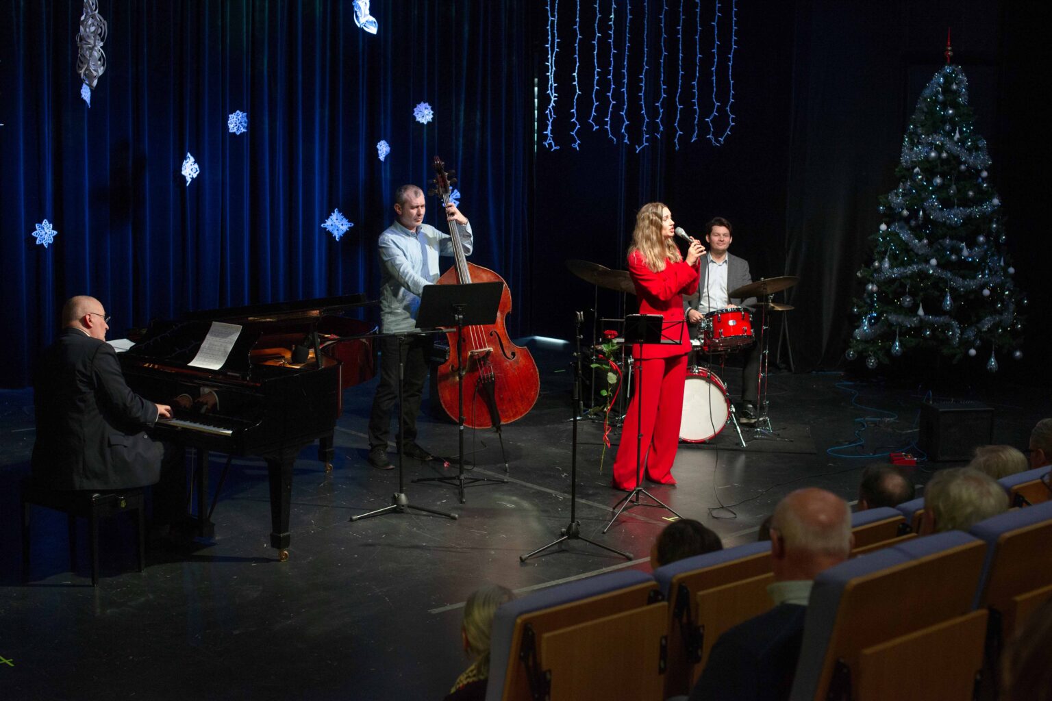 zdjęcie zespołu: kobieta w czerwonym garniturze, mężczyzna grający na kontrabasie oraz mężczyzna grający na perkusji