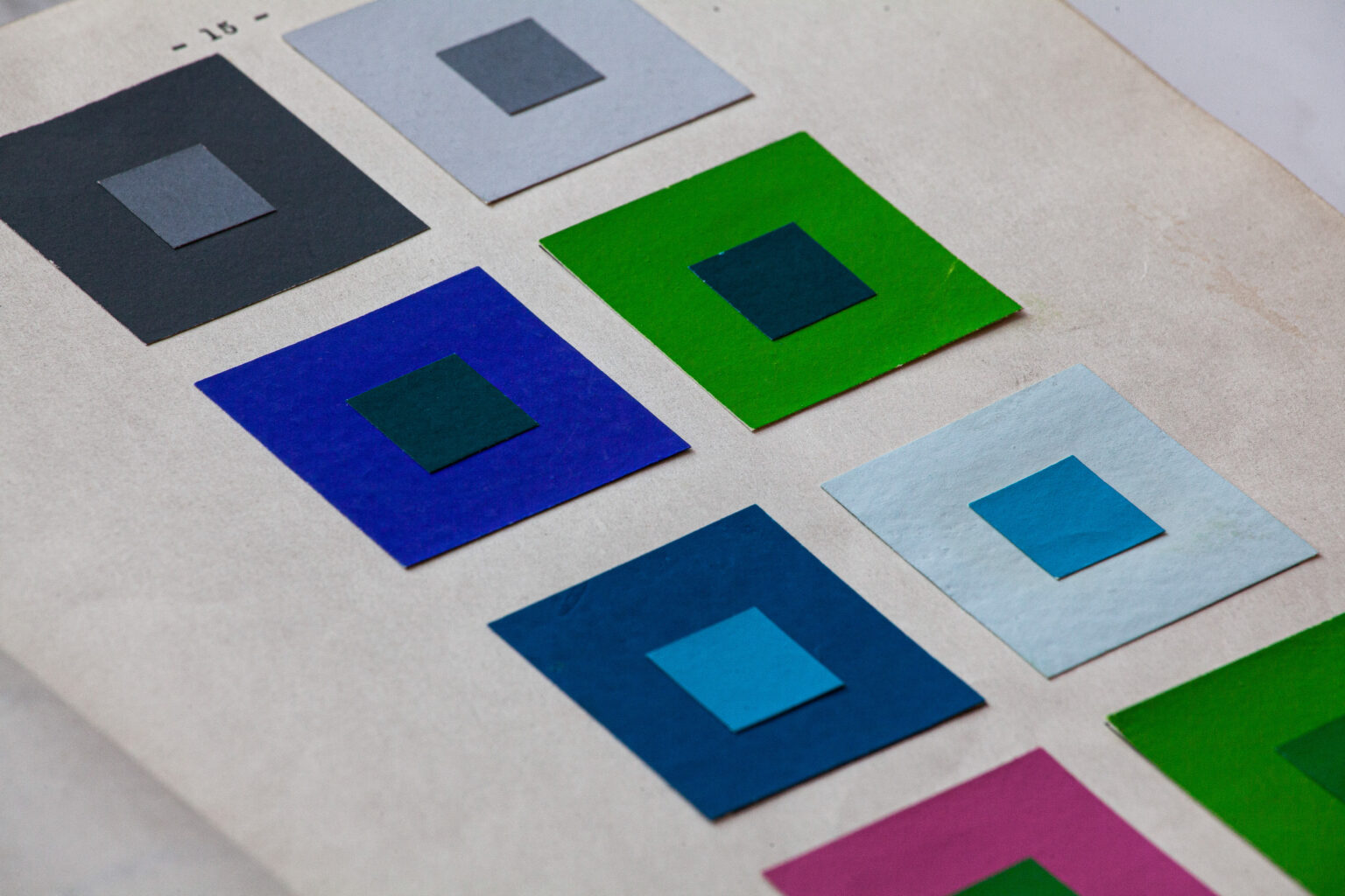 Na zdjęciu widać otwartą książkę na stronie z ilustracją rozszczepienia światła przez pryzmat.