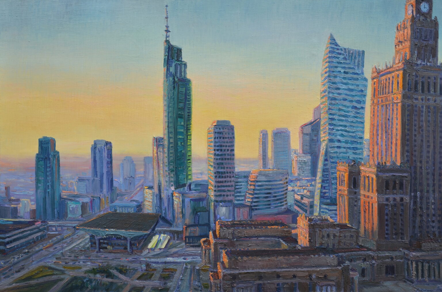 obraz przedstawia panoramę miasta o zachodzie słońca