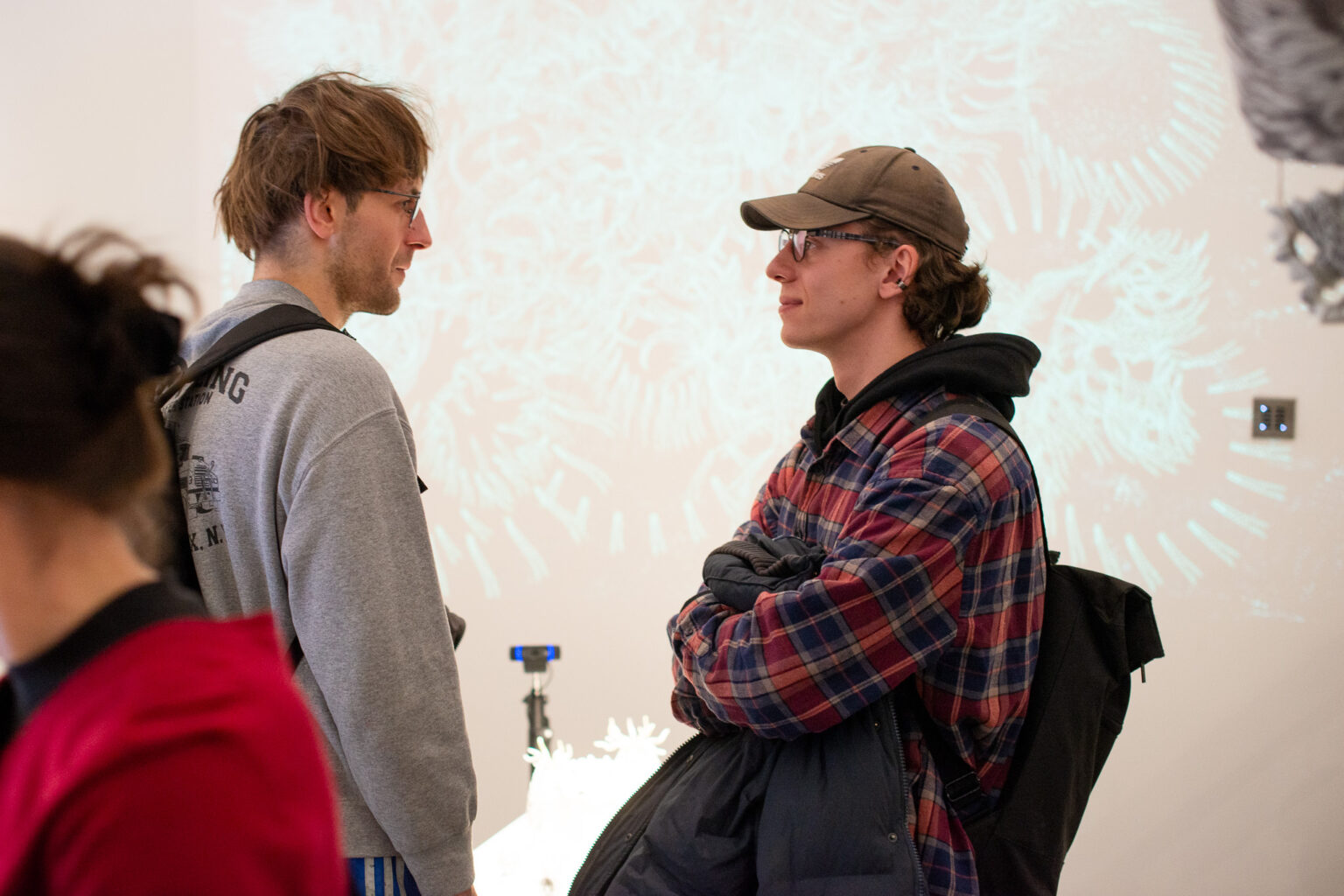 dwaj mężczyźni - jeden w czapce z daszkiem - rozmawiają