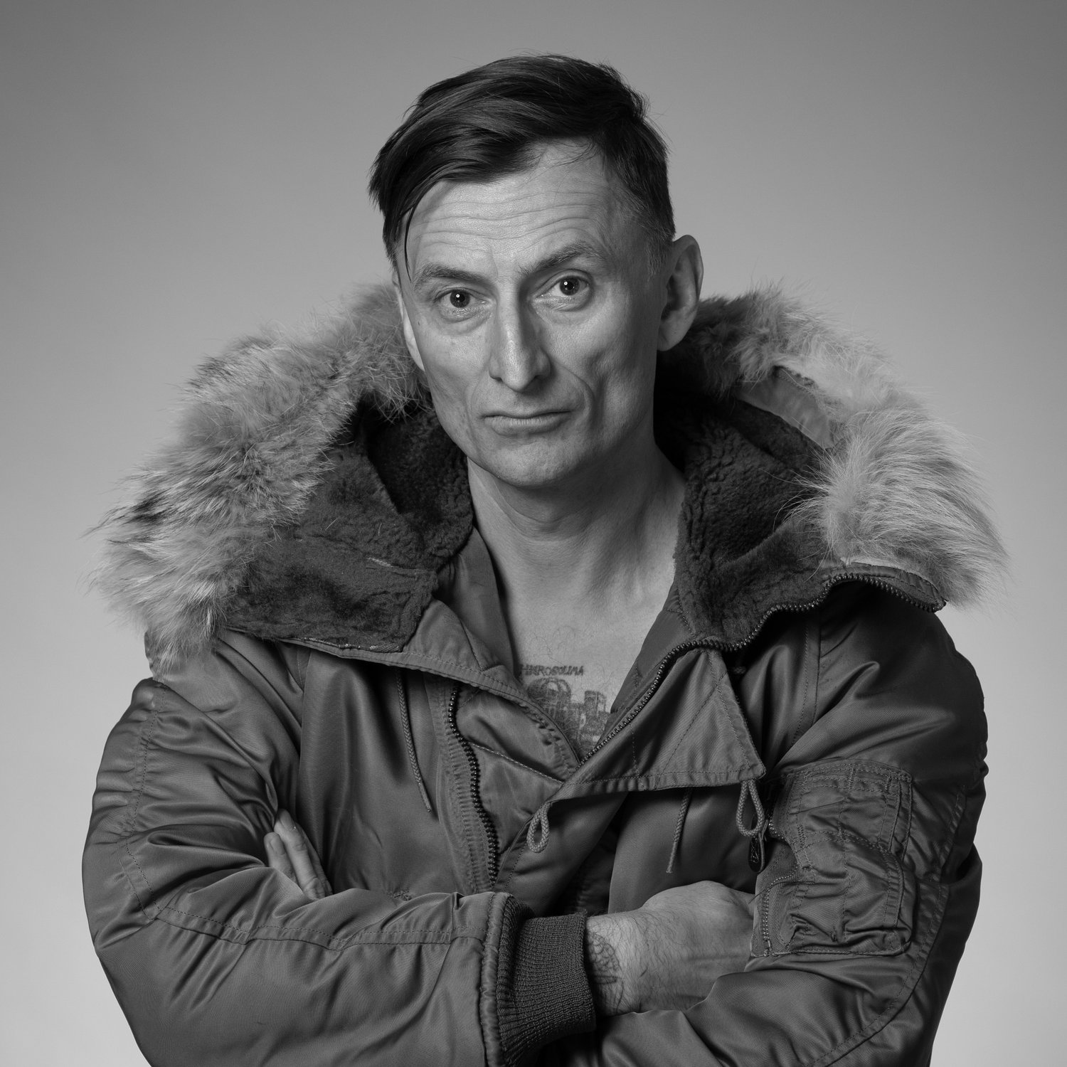 czarno-biały portret mężczyzny w zimowej kurtce z kapturem