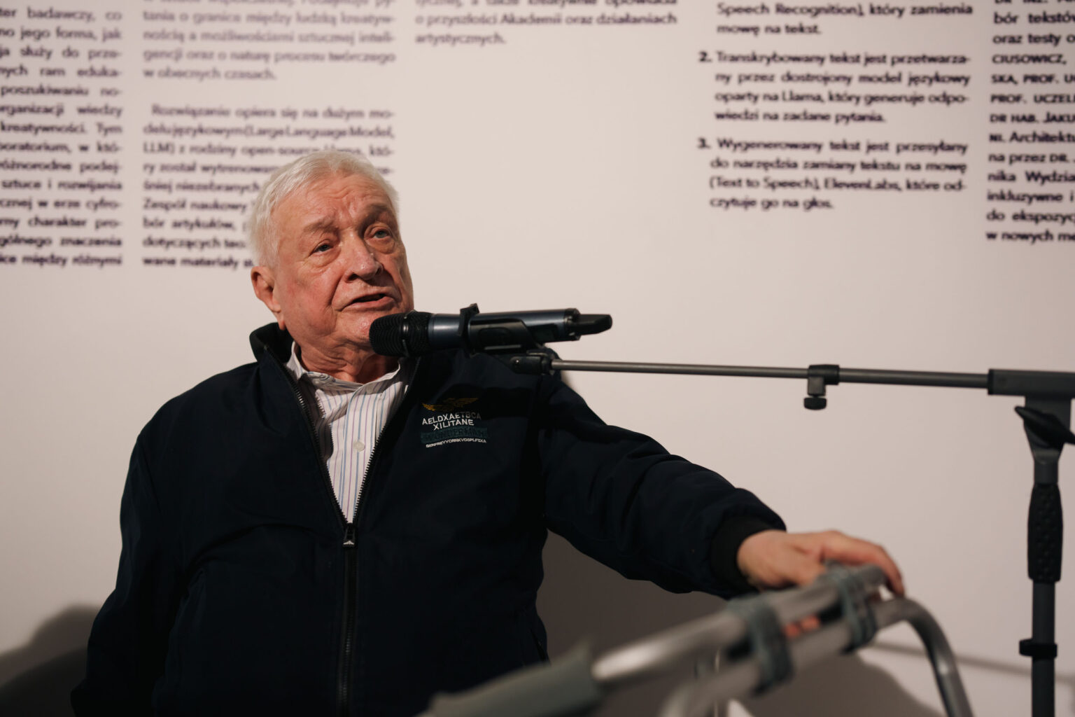 starszy mężczyzna mówi do mikrofonu