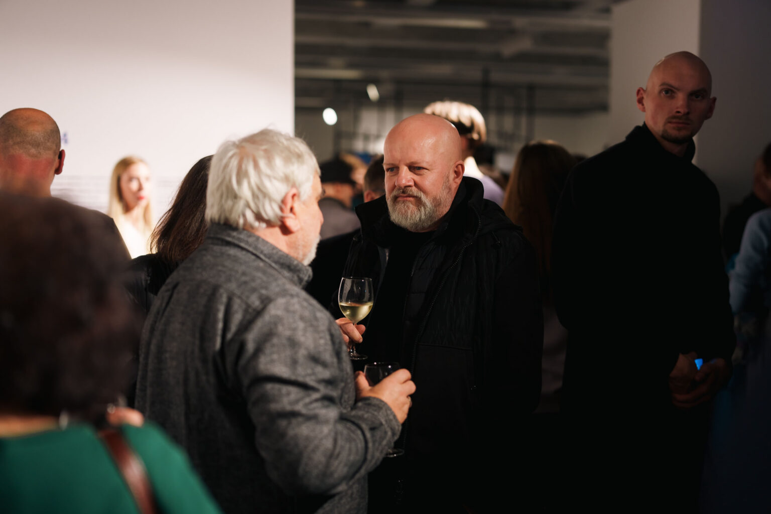 dwaj mężczyźni rozmawiają w przestrzeni galerii