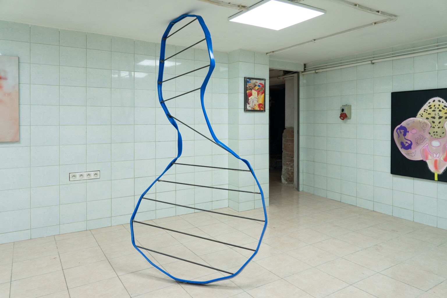 niebieska instalacja we wnętrzu, podłoga i ściany wyłożone kafelkami