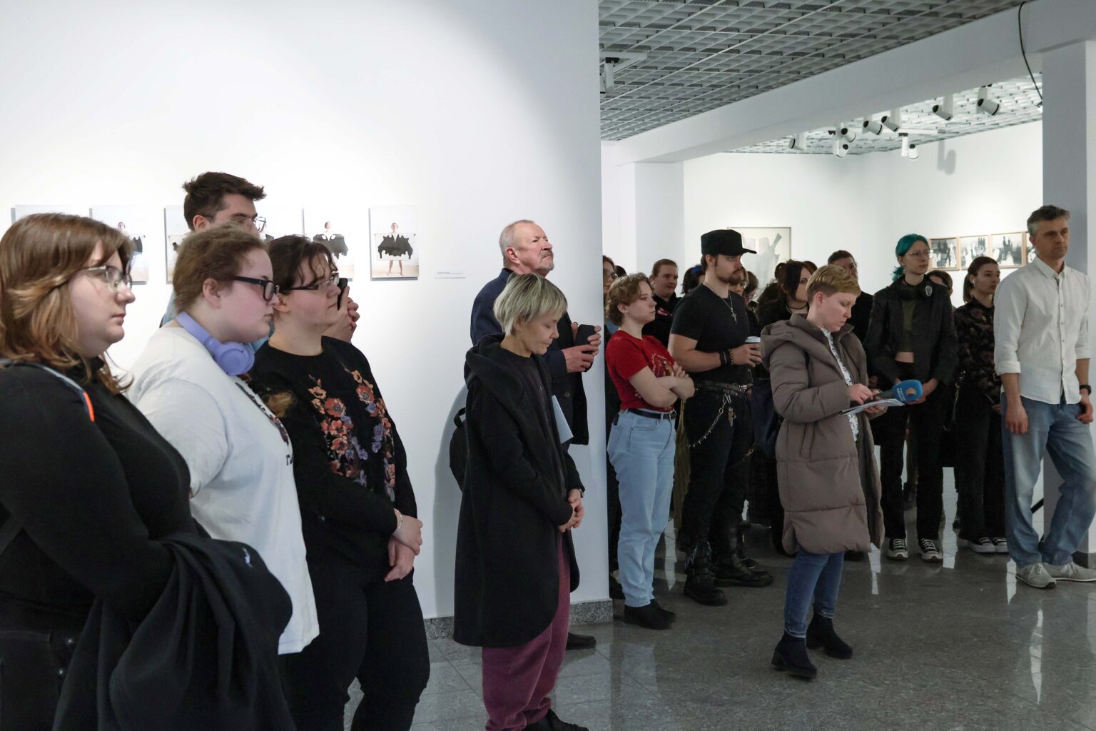 duża grupa osób w przestrzeni galerii