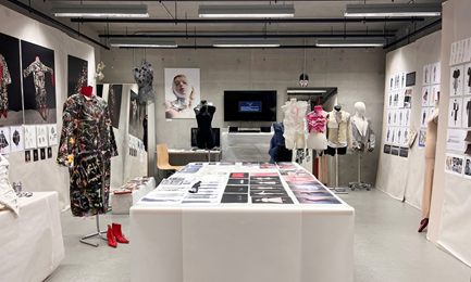 pracownia: projekty kostiumów na ścianach, długim stole i na manaekinach