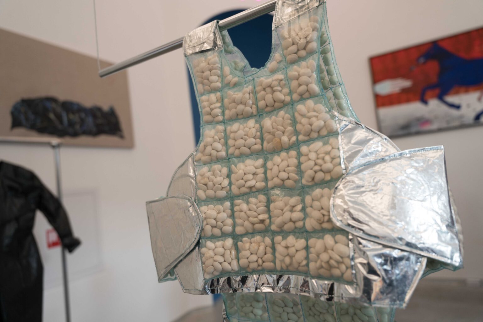 obiekt na wystawie - kamizelka z ziarnami w małych przeźroczystych kieszeniach