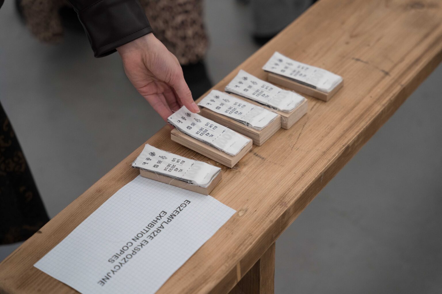 dłoń sięgająca po karteczki ułożone na półce