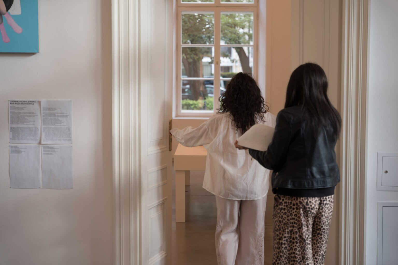 kobieta niesue duże białe naczynie podążając kobietą w białym ubraniu